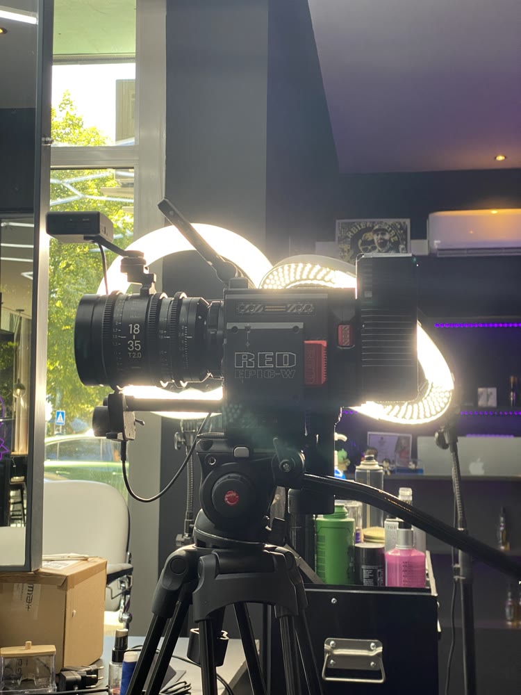 RED-Kamera mit Cine-Objektiv vor Ringlichtern im Barbershop