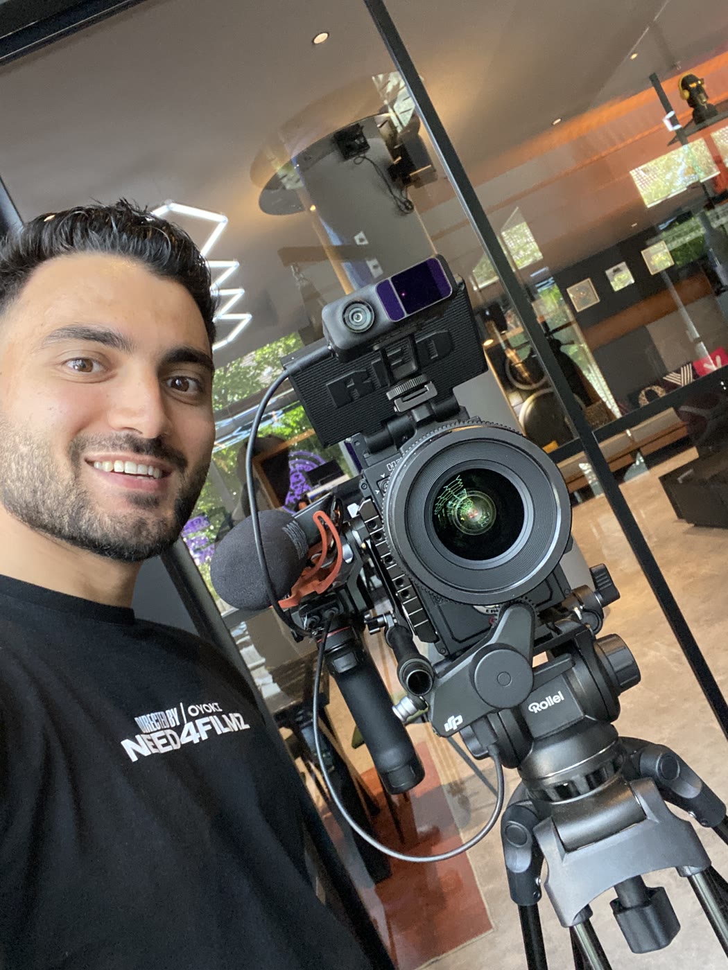 Oktay im Need4Filmz-Shirt neben seiner RED-Kamera auf dem Stativ