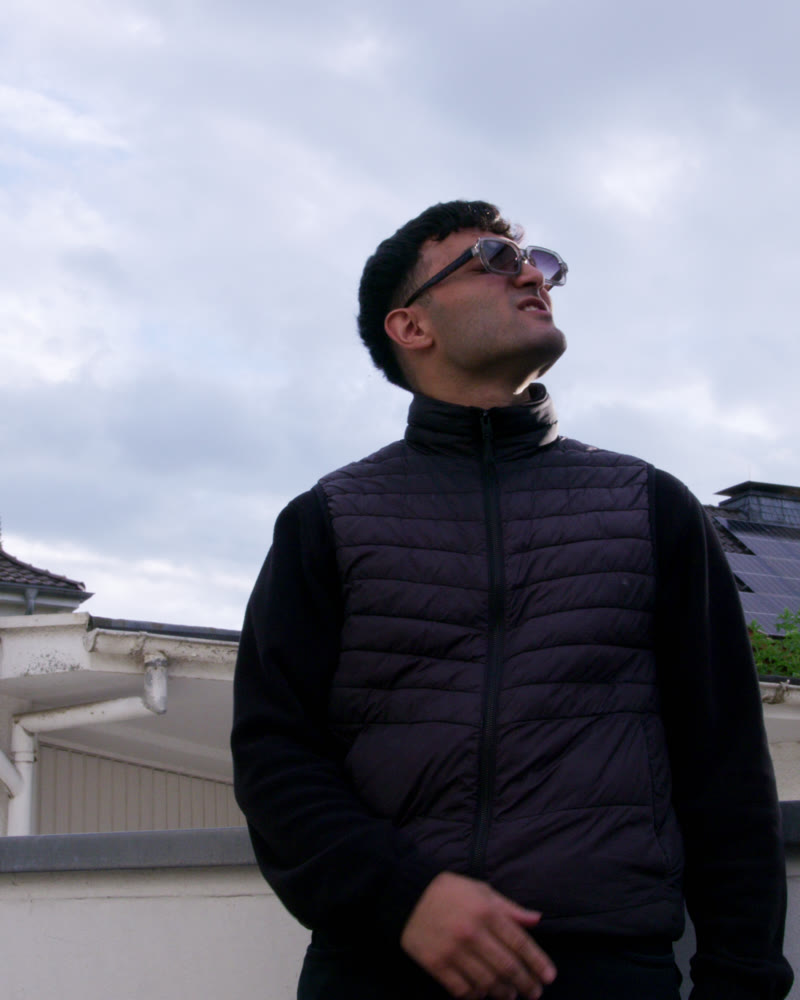 Rapper mit Sonnenbrille blickt in den Himmel