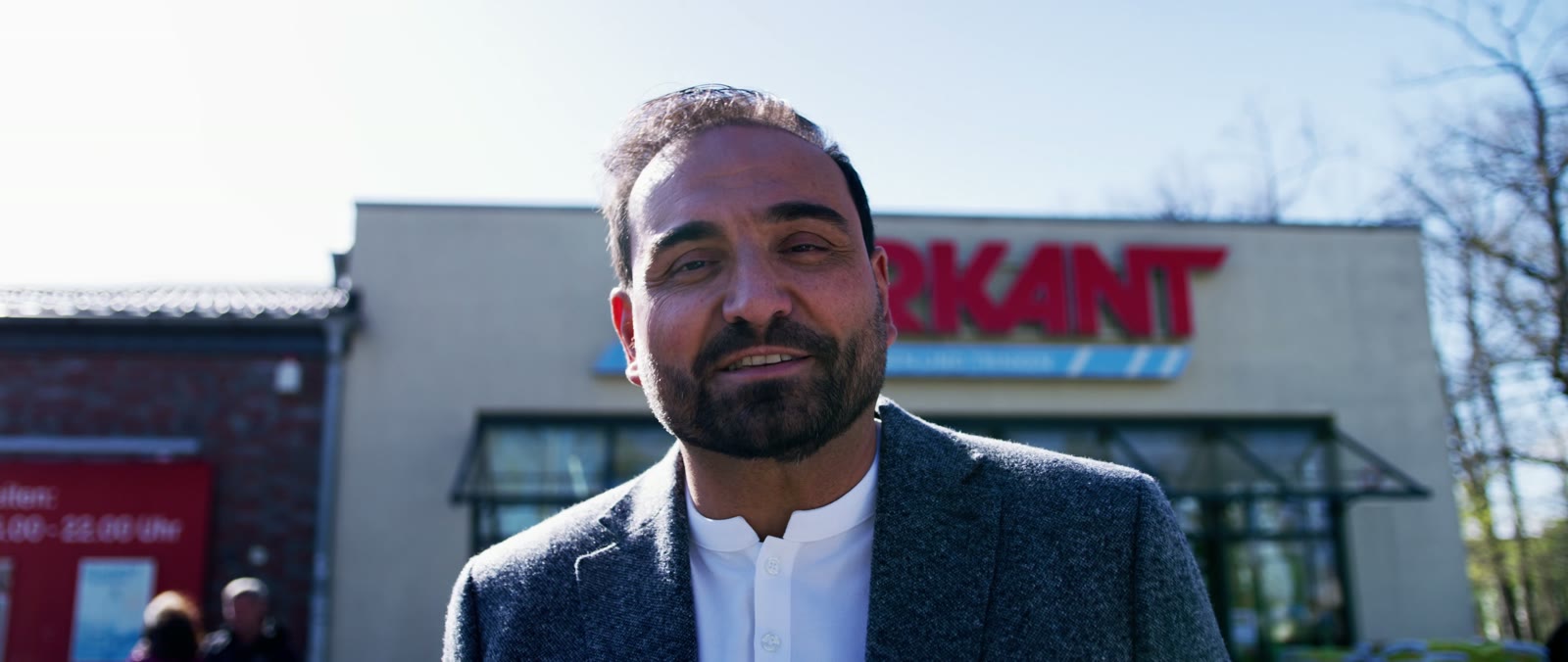 Lächelnder Inhaber vor dem Markant-Markt
