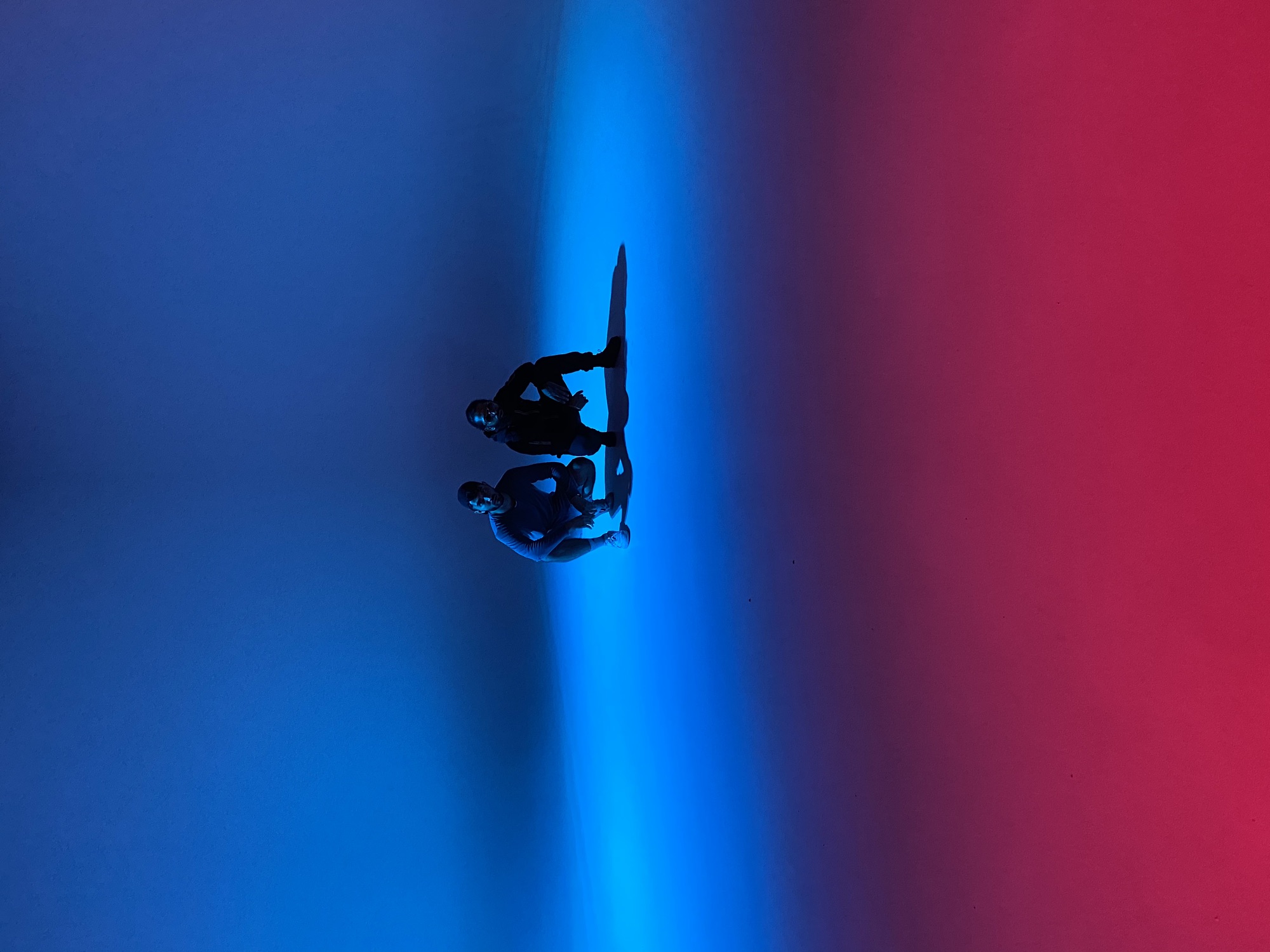 Zwei Personen im leeren Studio mit blauem und rotem Licht